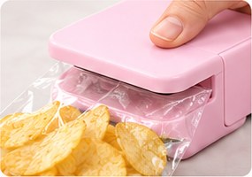 A hand pressing SnapSeal Mini onto a bag of chips